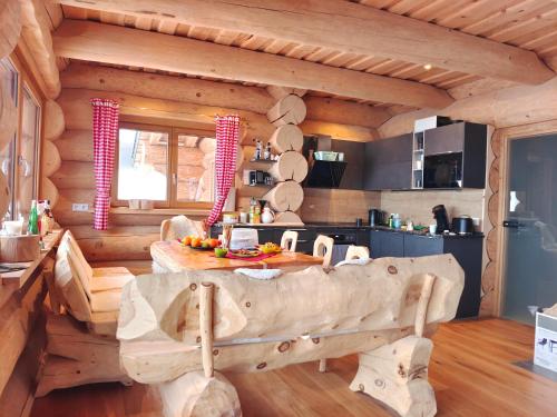 Una cocina de cabaña de troncos con un gran banco de madera en una habitación. en Falkenblick, en Hochrindl