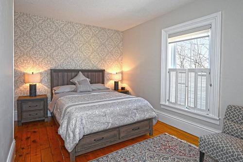 a bedroom with a bed and a window and a chair at Our Space the Perfect Place B&B in Picton