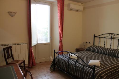 1 dormitorio con 1 cama, 1 silla y 1 ventana en Locanda Fosca Umbra, en Narni