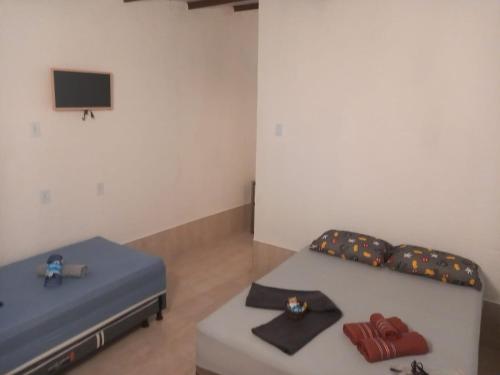 Habitación con 2 camas y TV en la pared. en Na Casa da Anna, en Porto Seguro