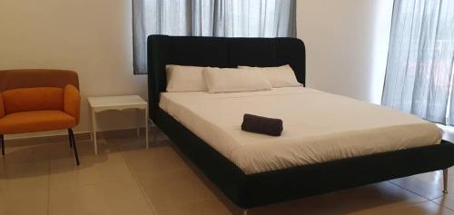 a bed with a black headboard and a chair in a room at Muntala's Guest House in Hohoe
