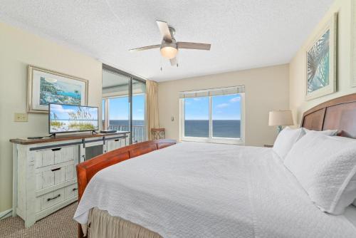 1 dormitorio con 1 cama y escritorio con TV en Summerchase 704, en Orange Beach