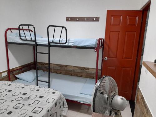 Zimmer mit 2 Etagenbetten neben einer Tür in der Unterkunft J79 Apartamentos Vacacionales in Ibagué