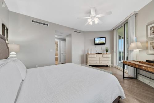 1 dormitorio blanco con 1 cama blanca y TV en Lost Key C501, en Perdido Key