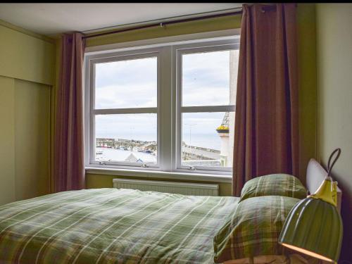 a bedroom with a bed and a large window at Sea View in Anstruther
