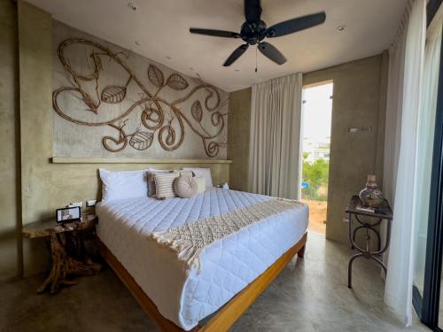 een slaapkamer met een bed en een plafondventilator bij Xkeban Tulum Adults Only in Tulum