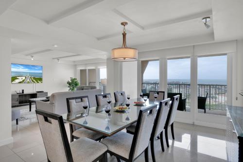 comedor con mesa de cristal y sillas en My ideal home by the beach! Classy Bayview, beachfront resort, shared pools & jacuzzi, en South Padre Island