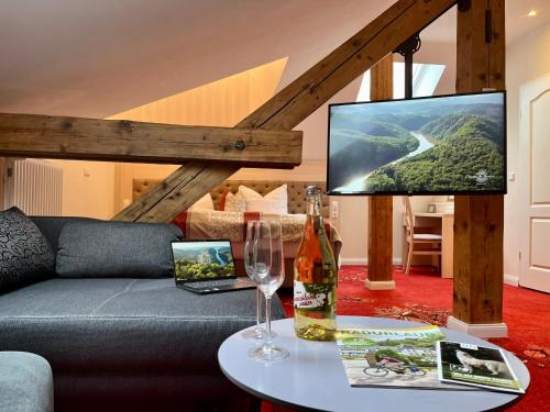 a living room with a couch and a tv at Hotel Stadtvilla Laux in Merzig
