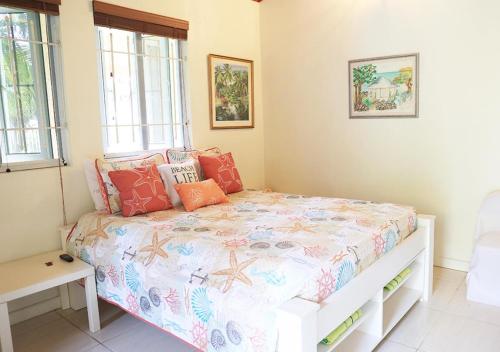 um quarto com uma cama e duas janelas em Coconut Palms Hideaway em Nassau