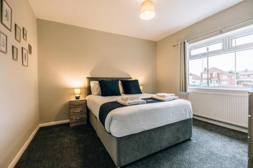 um quarto com uma cama grande e uma janela em Wolviston House By Horizon Stays em Stockton-on-Tees