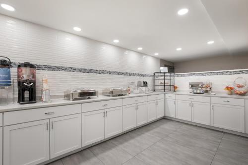 a large white kitchen with white cabinets and appliances at Clarion Hotel & Convention Center Joliet in Joliet