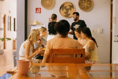 um grupo de pessoas sentadas à volta de uma mesa em Hostik Hostal em Mérida
