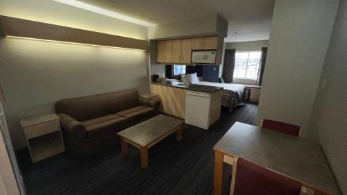 ein kleines Wohnzimmer mit einem Sofa und einem Bett in der Unterkunft America's Best Value Inn and Suites - Jackson in Jackson