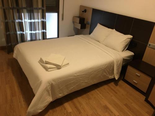 um quarto com uma grande cama branca com dois livros em Apartamento Calle Turco 13 em Zaragoza