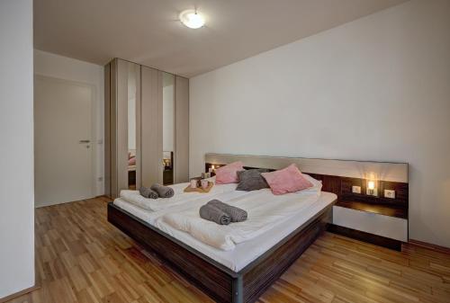 a large bedroom with a large bed with pink pillows at Carin Deluxe II in Vienna