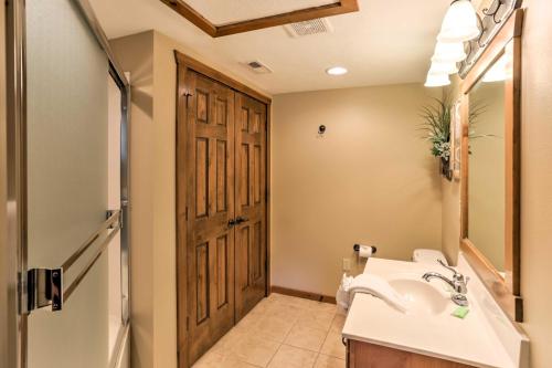 a bathroom with a sink and a wooden door at Branson Home with Game Room, Near Silver Dollar City in Branson