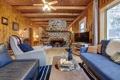 a living room with blue couches and a fireplace at Nelson Log Cabin in Rivière-Rouge in Rivière-Rouge