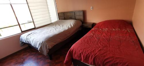 a bedroom with a bed and two windows at Dpto frente a Cavancha 6P in Iquique