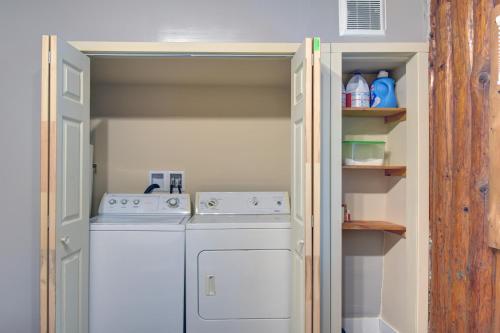 a white washer and dryer in a small kitchen at Nelson Warm Log Cabin with Private Hot Tub in Rivière-Rouge