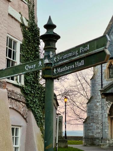 a green street sign in front of a building at Church View a first floor apartment in the heart of historic Topsham in Topsham