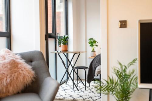 a living room with a chair and a table with plants at The Upside Down Eco House in Bristol