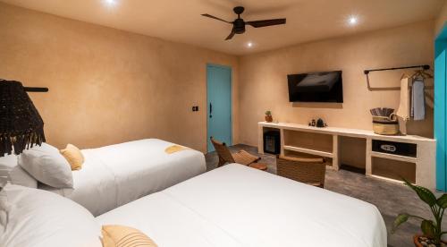 1 dormitorio con 2 camas y escritorio con TV en Bacalari - Adults Only en Bacalar