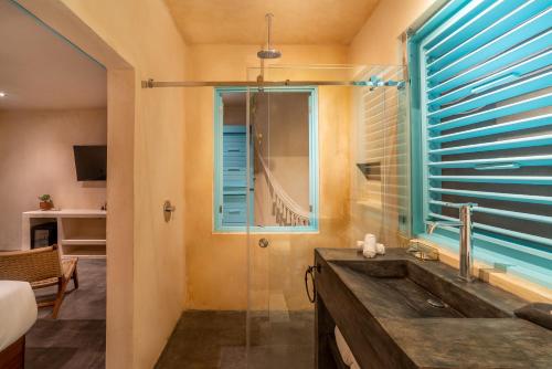 La salle de bains est pourvue d'un lavabo et d'une fenêtre. dans l'établissement Bacalari - Adults Only, à Bacalar