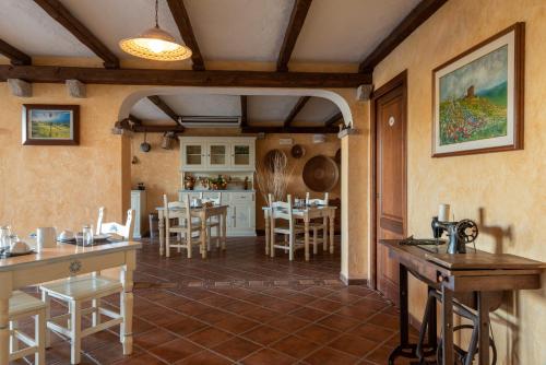 eine Küche und ein Esszimmer mit Tischen und Stühlen in der Unterkunft Affittacamere S'Alzola in Porto Rotondo