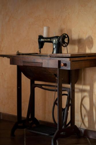 an old sewing machine sitting on top of a wooden table at Affittacamere S'Alzola in Porto Rotondo