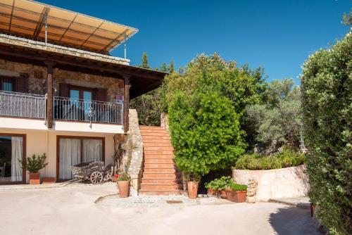 a house with a staircase in front of it at Affittacamere S'Alzola in Porto Rotondo