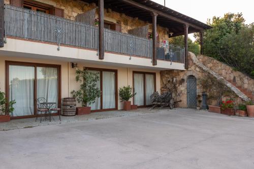 a building with a balcony and a patio at Affittacamere S'Alzola in Porto Rotondo