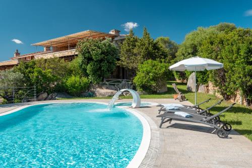 a swimming pool with two chairs and an umbrella at Affittacamere S'Alzola in Porto Rotondo