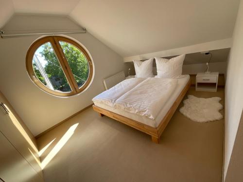 Schlafzimmer mit einem großen Bett und einem Fenster in der Unterkunft Sonniges Jura Loft im Golf Paradies Hilzhofen in Pilsach