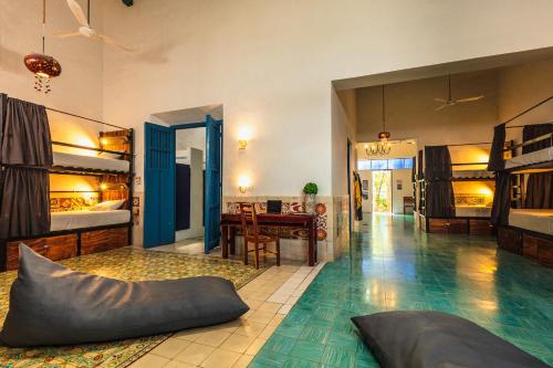 Che Nomadas Mérida Hostel Adults Only في ميريدا: غرفة كبيرة مع سرير بطابقين وطاولة