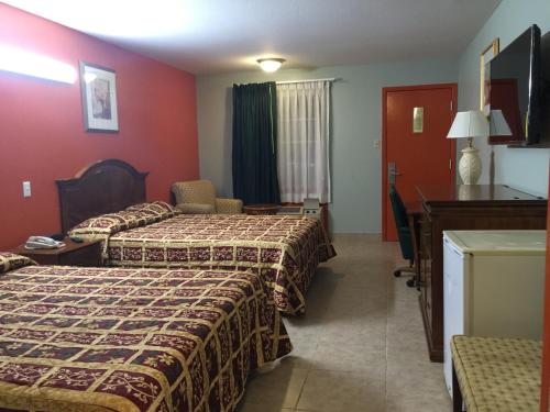 a hotel room with two beds and a piano at Texas Inn in Brownsville