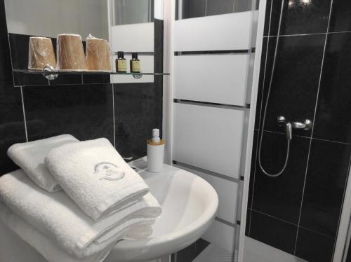uma casa de banho com um lavatório, um chuveiro e toalhas em Pensión NAVIA A Pontenova em A Pontenova