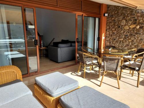 sala de estar con mesa, sillas y sofá en Villa Happiness - Luxury chalet with sea view, en Las Palmas de Gran Canaria