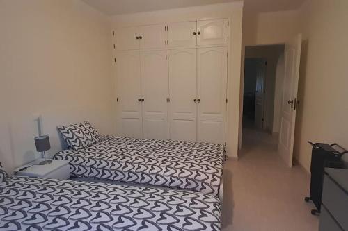 een slaapkamer met 2 bedden en een grote kast bij Oásis do João e da Dalila in Portimão