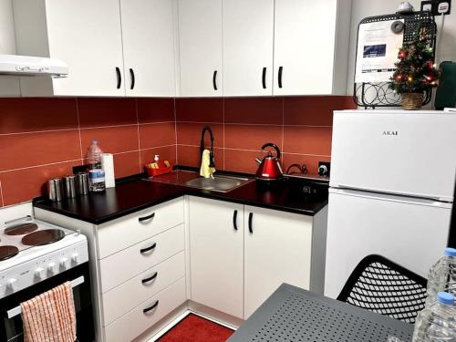 La cuisine est équipée de placards blancs et d'un réfrigérateur blanc. dans l'établissement Cute Penthouse, à Marsaskala