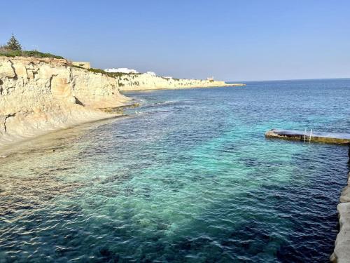 a large body of water next to a beach at Cute Penthouse in Marsaskala