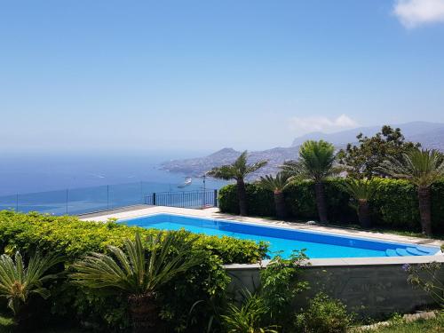 a swimming pool with a view of the ocean at Neves by BCA Villas in São Gonçalo