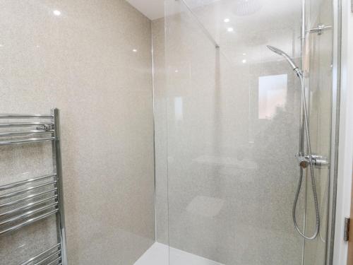 a shower with a glass door in a bathroom at Clover Cottage in Newcastle upon Tyne