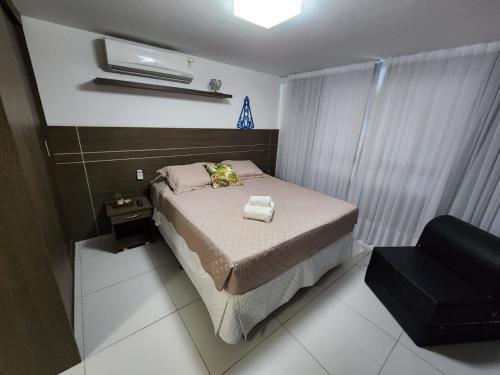 1 dormitorio pequeño con 1 cama y 1 silla en Israel Flat da Mar & Sol, en João Pessoa