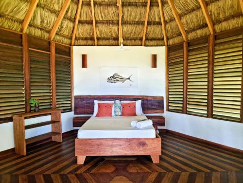 a bedroom with a bed in a room with windows at The Jaguars Jungle Rainforest Lodge - All meals included in San Pedrillo