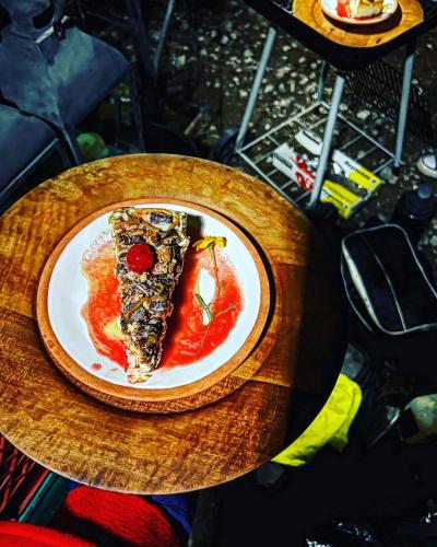 a slice of pizza on a plate on a table at Pequeña cabaña mágica con chimenea interior in Arteaga