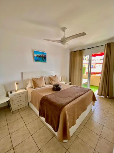 a bedroom with a large bed and a window at Bonito apartamento cerca del mar in Puerto de Santiago