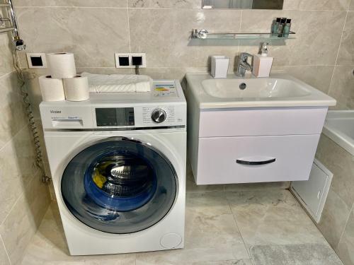 uma máquina de lavar roupa e um lavatório na casa de banho em Шикарные апартаменты с прекрасным видом в лучшем районе em Almaty