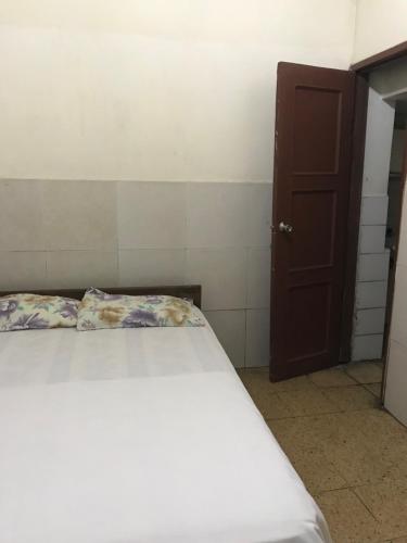 1 dormitorio con cama y puerta marrón en Hotel Luque en Guayaquil