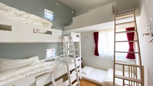a dorm room with bunk beds and a ladder at MARBLE B&B in Kashima