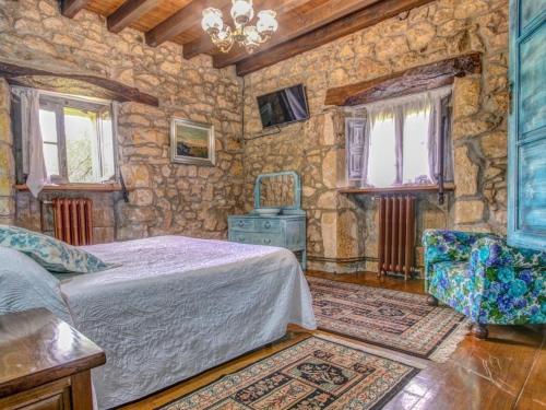 a bedroom with a bed and a stone wall at Casona Dos Lagos in Villanueva
